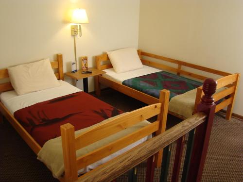 a hotel room with two beds and a lamp at Roosevelt Inn Mount Rushmore in Keystone