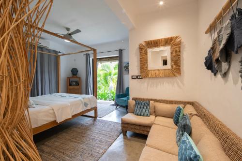 um quarto com uma cama e um sofá em Koki Bonheur by muse villas em Poste Lafayette