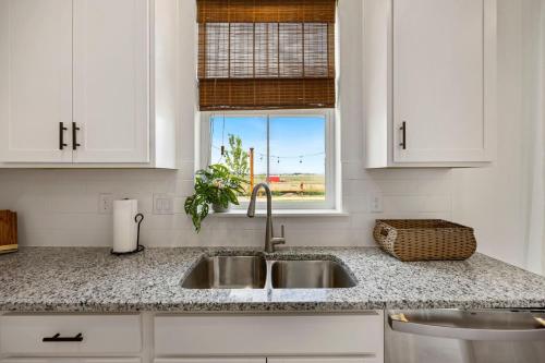 uma cozinha branca com um lavatório e uma janela em Spacious Home, Great Backyard with Mtn Sunset Views! em Loveland