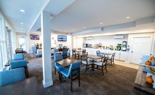 ein Esszimmer mit Tischen und Stühlen und eine Küche in der Unterkunft Days Inn by Wyndham Bar Harbor in Bar Harbor
