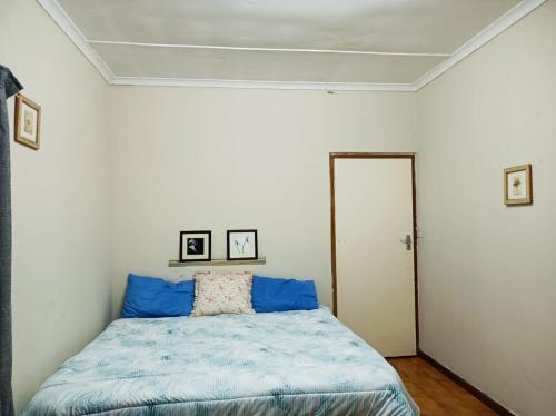 a bedroom with a bed with a blue comforter at 18 on Shores in Pietermaritzburg