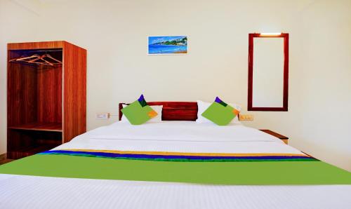 una camera da letto con un letto bianco e una coperta arcobaleno di Treebo SS Residency With Mountain View a Dapoli
