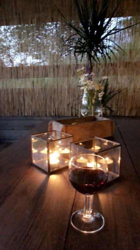 a glass of wine and candles on a wooden table at 15 min från Ullared! Ny stuga med hög standard! in Älvsered