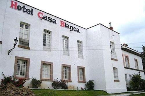 a white building with a sign on the side of it at Hotel Casa Blanca in El Oro de Hidalgo