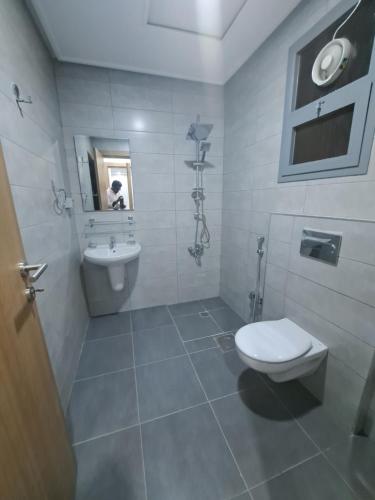 a bathroom with a toilet and a sink at Garden Dahlia Hotel Apartment - Formerly Regency Dahlia - Farwaniya in Kuwait