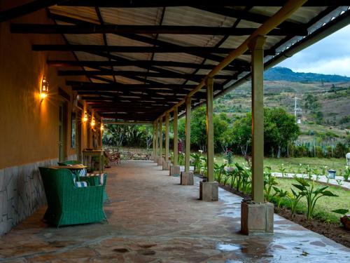a building with a covered walkway with a table and chairs at Tambo Sapalanchan in Lamud