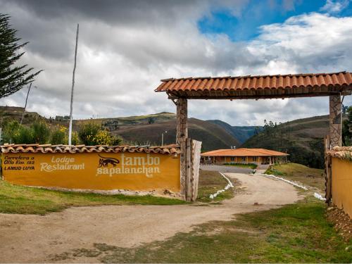 a sign on a dirt road next to a building at Tambo Sapalanchan in Lamud