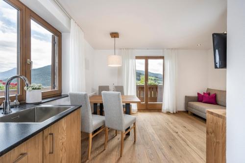 a kitchen and living room with a table and chairs at Apartments Untersüßgut Eben in Eben im Pongau