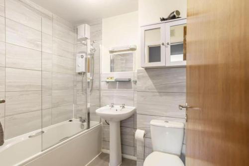 een witte badkamer met een wastafel en een toilet bij The SUMMIT Apartment - Aberdeen City Centre - Perfect for Long and short Stay in Aberdeen