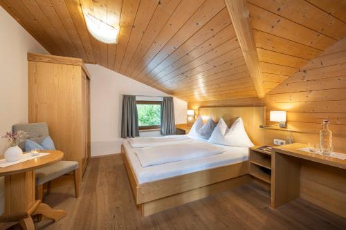 sypialnia z dużym łóżkiem i drewnianym sufitem w obiekcie Apartments Untersüßgut Eben w mieście Eben im Pongau