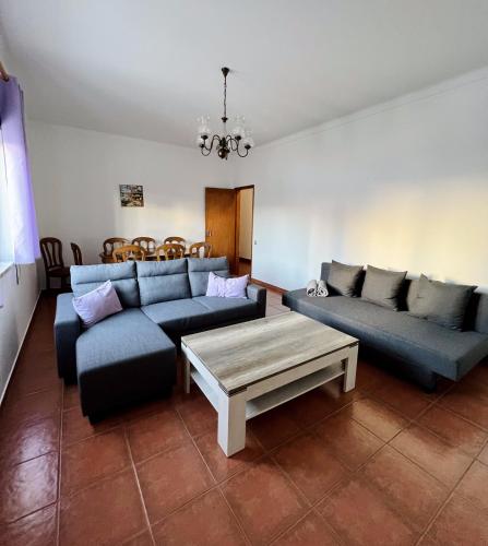 a living room with two couches and a coffee table at Apartamentos Guiomar Campos in Porto Covo