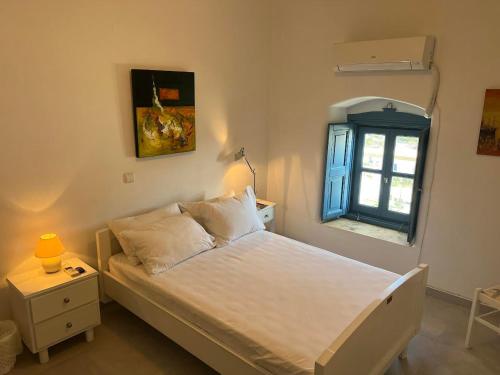 Aegean Dream 2 في Panteli: غرفة نوم بسرير ابيض ونافذة