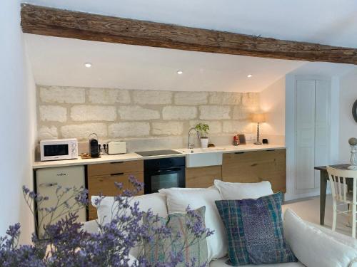 a living room with a couch and a kitchen at Chez Beth in Saint-Rémy-de-Provence