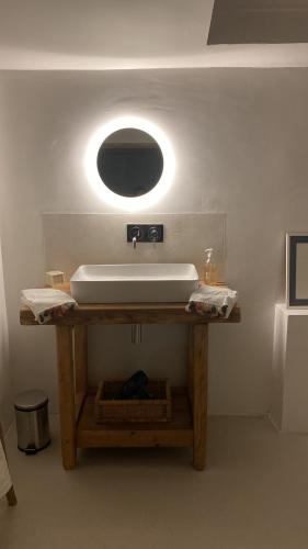 a bathroom with a sink and a mirror on a table at Chez Beth in Saint-Rémy-de-Provence
