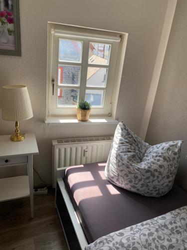 a bedroom with a bed with a pillow and a window at Altstadt Pension Herborn in Herborn