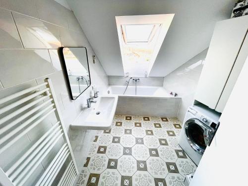 ein Badezimmer mit einer Badewanne, einem Waschbecken und einer Waschmaschine in der Unterkunft Résidence LeRêve in Wien
