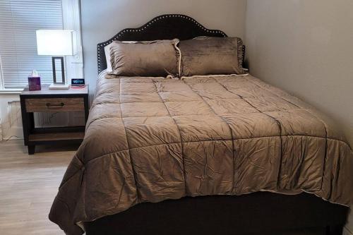 Ce lit se trouve dans une chambre avec une lampe et une table. dans l'établissement Retreat Suite 1 - Cozy Downtown Getaway, à Grand Rapids