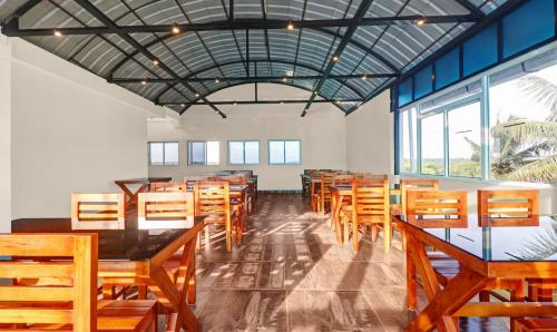 a dining room with wooden tables and chairs at Treebo Pushpak Service Apartment in Cochin