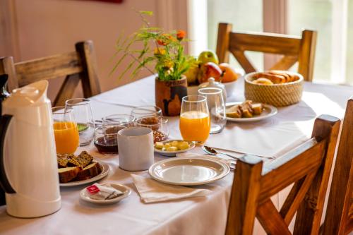 una mesa con alimentos para el desayuno y zumo de naranja en ella en Estancia San Agustin en Curuzú Cuatiá
