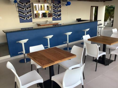 un ristorante con tavoli in legno e sedie bianche di Hotel Blue Malecón And Spa a Santo Domingo