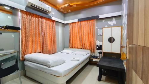 a bedroom with a bed and a desk and a television at Hotel Samrat in Baharampur