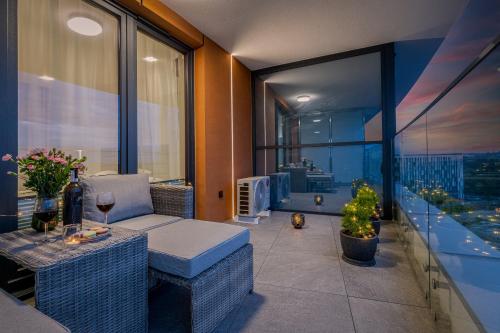 uma varanda com um sofá e uma mesa com um copo de vinho em Apartament Mateo Inn na Cracóvia