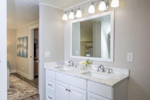 a white bathroom with two sinks and a mirror at Couples Getaway - Walk to UNC - Free Cruiser Bikes in Greeley