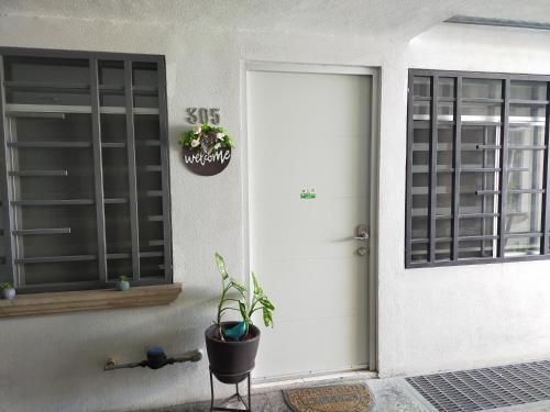 a white front door of a house with a potted plant at Luxury departament Centenario in Guadalajara