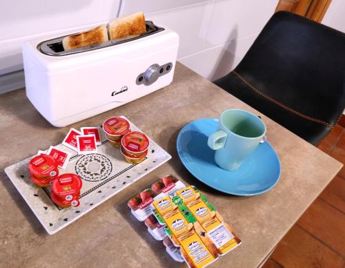 a table with a cup of coffee and a toaster at La Casa de las Nereidas in Cuenca