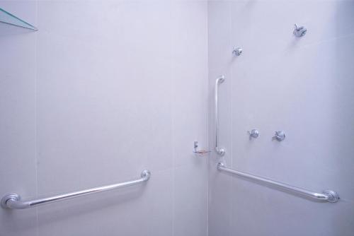 a bathroom with a shower with two hand rails at GoÁtica Aeroporto Congonhas in Sao Paulo