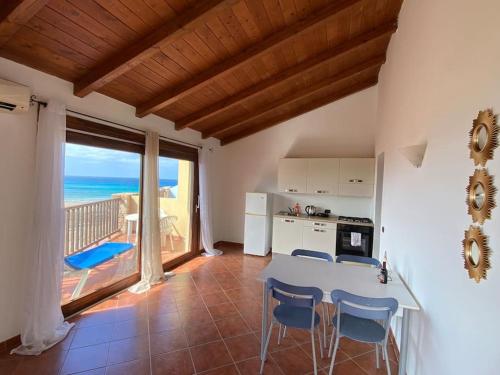 a kitchen with a table and a view of the ocean at Porto Antigo 1 - Beach apartments in Santa Maria