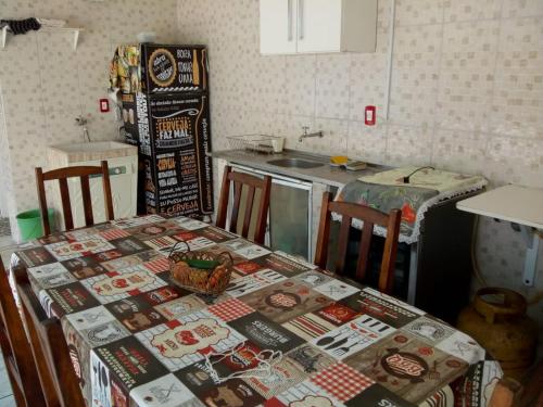 uma cozinha com uma mesa com uma toalha de mesa em Ilha Comprida-Casa Madeira-Conforto Familiar em Ilha Comprida