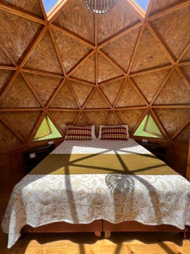 a bedroom with a large bed in a wooden room at Glamping y Chalet Aventura Park Villa De Leyva La Periquera in Villa de Leyva