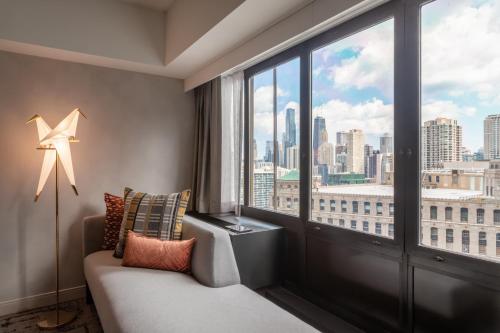 a room with a couch and a large window at voco Chicago Downtown - Riverwalk by IHG in Chicago