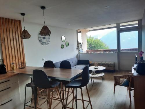 une cuisine et un salon avec une table et des chaises dans l'établissement SUPERBE APPARTEMENT REFAIT A NEUF avec garage, à Orcières