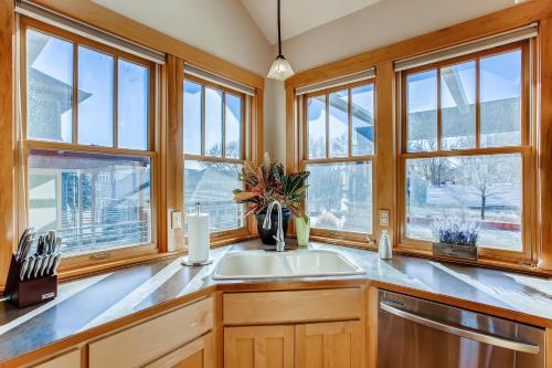 a kitchen with windows and a sink and a counter at Brilliant Posh Home - Backs to Poudre River Trail! in Fort Collins