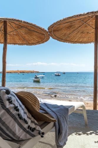 a beach with a chair and an umbrella and the ocean at Pallas Seaside 1 in Athens