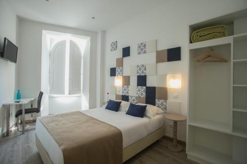 a bedroom with a bed and a table and a window at Thomar Story - Guest House in Tomar