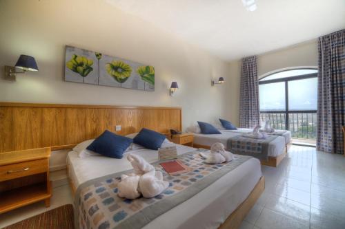 a hotel room with two beds with towels on them at Bella Vista Hotel in St. Paul's Bay