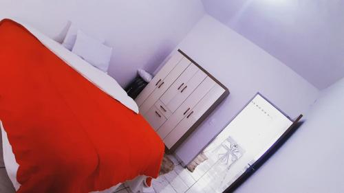 a room with a red bed and a bathroom at LoftStudio16 Próximo a Fiat a Br381 e Via expressa in Betim