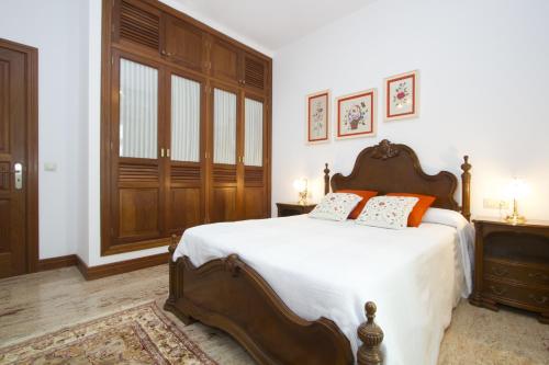 a bedroom with a bed with white sheets and orange pillows at Villa Remedios in Teguise
