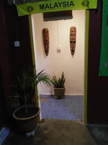 una puerta con una señal que diga malaysia y dos máscaras en Nazri Nipah Camp Pangkor, en Kampung Teluk Nipah