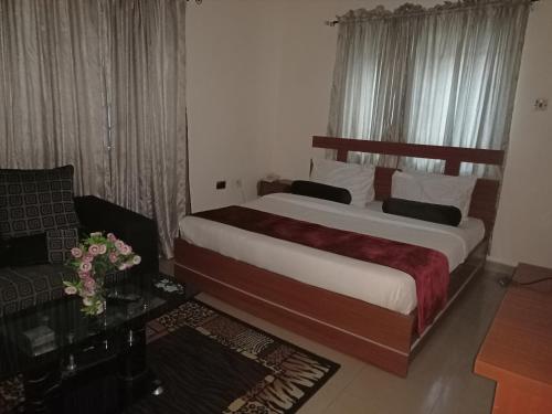 A bed or beds in a room at Villa Nuee Hotel & Suites Utako, Abuja