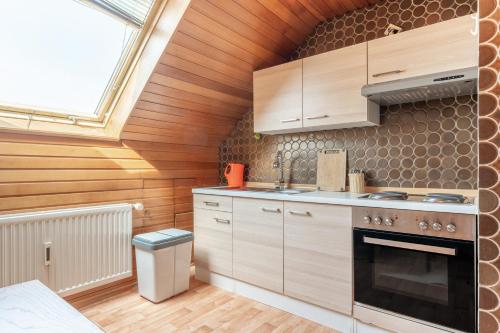 a kitchen with wooden cabinets and a stove at Hotel Kniestedter Hof in Salzgitter-Bad