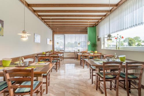 a dining room with wooden tables and chairs at Hotel Kniestedter Hof in Salzgitter-Bad