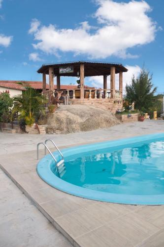 a swimming pool in a yard with a gazebo at - Belezas do Monte Chalé e Suíte- La na Roça in Monte das Gameleiras