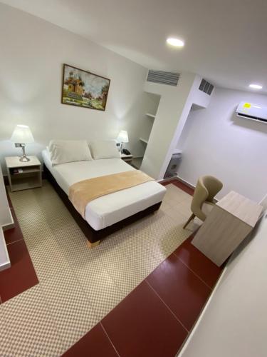 a bedroom with a large bed and a staircase at Hotel Casa Colonial in Barranquilla