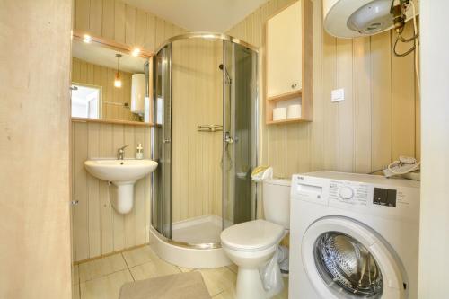 a bathroom with a washing machine and a washer at ORZECHÓWKA in Lądek-Zdrój