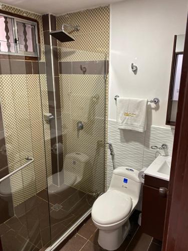a bathroom with a toilet and a glass shower at Hotel Casa Colonial in Barranquilla