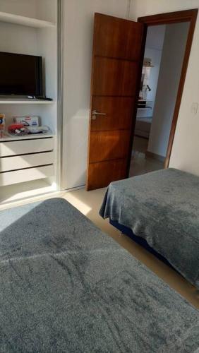 a bedroom with a bed and a closet with a television at Hermoso conjunto residencial con piscina in Asunción